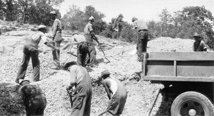 Project #2720 District 2: The resurface and repair of various streets throughout the City of Danville, KY, are embraced in Project #2720. Men loading stone for use in water-bound macadam base during repair of streets. View photographed July 28, 1936