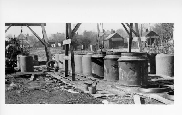Project # 1579 District 1: The construction and installation of concrete storm sewers in various parts of Madisonville, KY, has been completed under Project #1579. View, photographed November 6, 1936, shows reinforced concrete pipe being made for use in storm sewer construction