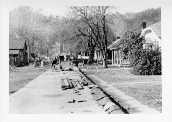 Project #3111 District 4: Project #3111 is the construction of 1300 lineal feet of 30-foot concrete pavement with curb and gutter on Main and Court Streets in Frenchburg, KY. Concrete curb and street under construction in Owingsville. Photograph taken November 6, 1936