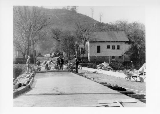 Project #3288 District 5: The grading and paving with concrete of various streets in the City of Prestonsburg, KY. The view, photographed November 12, 1936, shows the workers finishing section of concrete street in Prestonsburg