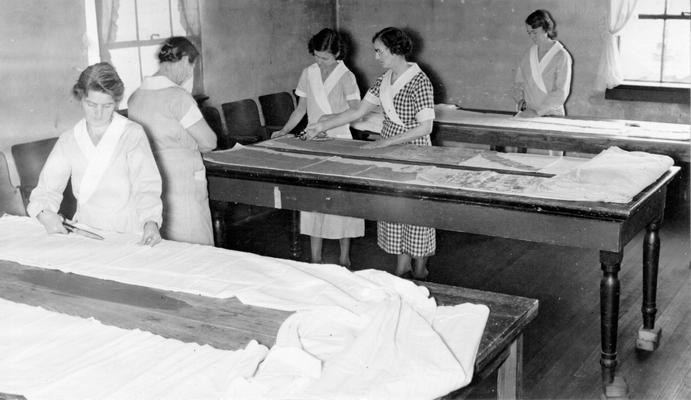 Project #3104 District 1: Training Work Center. Each woman in the Training Work Center learns to cut each of the garments she sews. This view is of the sewing room in Muhlenberg County