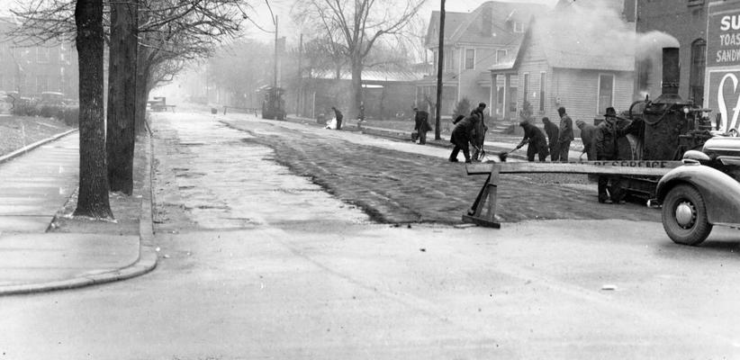Project #536 District 1: The resurfacing of various streets in Paducah, KY. Workmen shown placing blacktop surfacing material on street job in Paducah. View photographed December 19, 1936