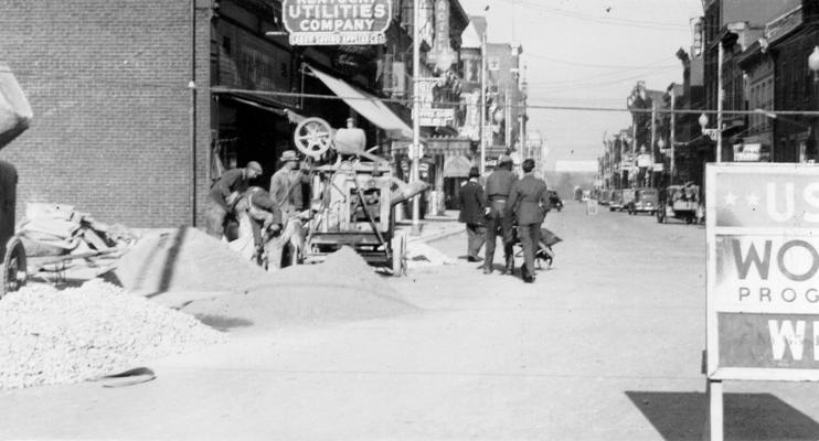 Project #3048 District 3: Master Project #3048, which was completed November 24, 1936, provided for the construction of concrete sidewalks in various parts of Paris, KY. View, photographed November 12, 1936, shows workers mixing concrete for new sidewalks on Main Street