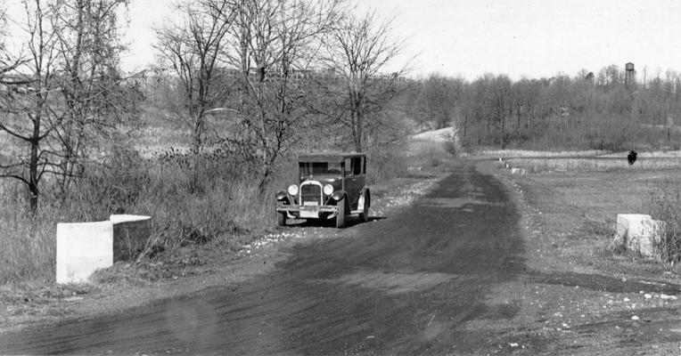 Project #1036 District 6: Rear entrance road to Waverly Hills. Construction of a concrete rear entrance road to Waverly Hills Sanitarium, a tuberculosis hospital near Louisville, KY, has been completed under Project #1036. View shows the rear entrance of cinder construction to Waverly Hills Sanitarium, before improvement of the road, photographed November 25, 1935