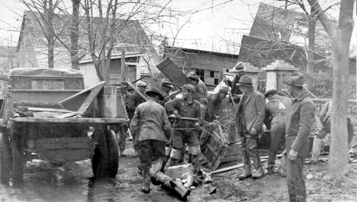 1937 Flood. Clean-up work in Louisville, KY. Cleaning up in the West End of Louisville, the WPA is performing a great job in helping to rehabilitate the flood stricken city. Note the overturned sheds and garages in the background. View photographed February 4, 1937