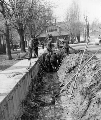 Project #365 District 1: This improvement of Elsey Avenue from Elm Street to the east city limits in the City of Bardwell, KY, includes the installation of storm drains, the construction of concrete paving, reinforced concrete pipe and curbing and gutter. Crew installing 36-inch concrete pipe made on this project. Photographed March 4, 1936