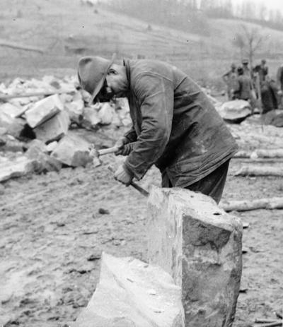 Project #583. WPA Project #583 provides for the construction of a native stone county school building at Hazel Green, KY. This structure will have four classrooms, a cloak room and an office. Quarrying and preparation of the stone is included as part of the project. Workmen cutting the stone to be used in construction of Hazel Green School. Note use of goggles as a safety measure. Photographed February 27, 1936