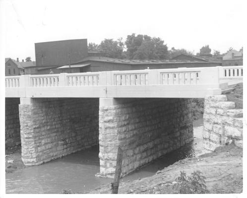 Concrete bridge on stone piers over a roadway