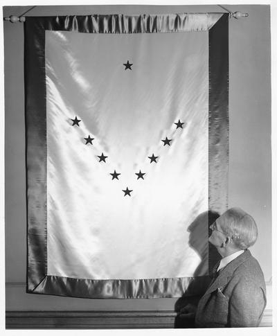 Large banner with stars in a V-shaped pattern; mounted on wall with a man looking up at it