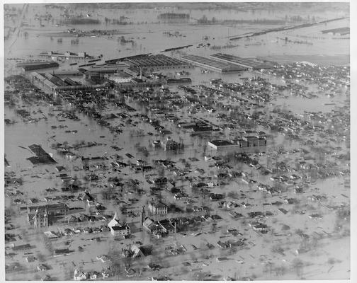 In the background can be seen the Jeffersonville Quartermasters Depot while the surrounding area is inundated.  Note the number of houses which have only their roofs out of water; 1/27/37