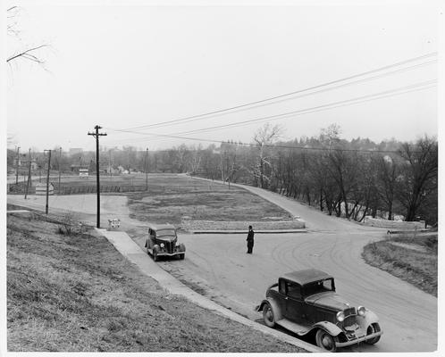 A WPA sign on a landscaping project; two cars parked at a curb--one is a 1935 Ford