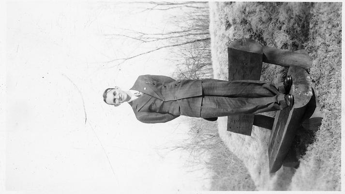 Man standing on a bench made from half-cuts of large logs