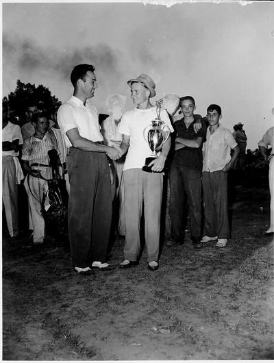 Young man is being presented an award cup