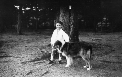 Man with collie next to tree