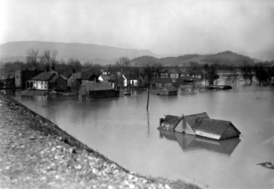Flood by railroad tracks, houses under water