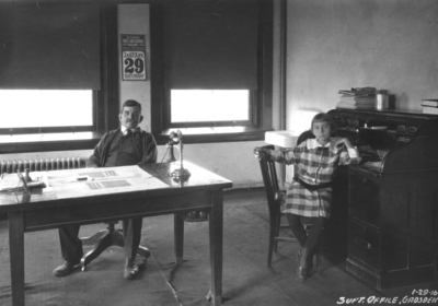Superintendents office, Gadsden, man at table and girl at desk