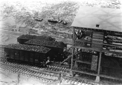 Train coal cars loaded from coal tipple