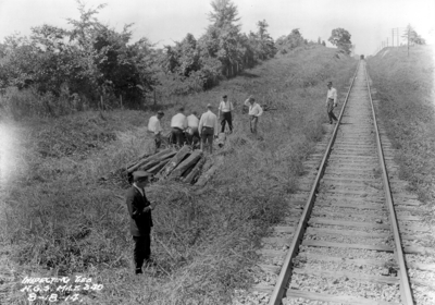 Men inspecting railroad ties, stretch of track