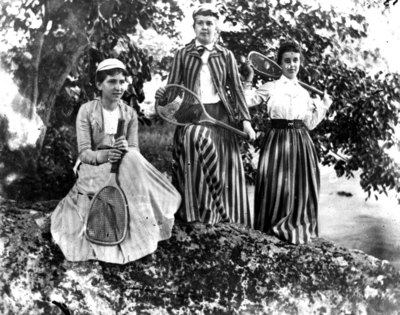 Three women in striped clothes carrying tennis rackets