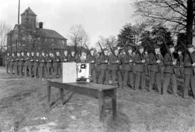 R.O.T.C. cadets drilling, phone or transmitter on table