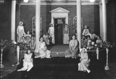 Girls in costume in front of a house