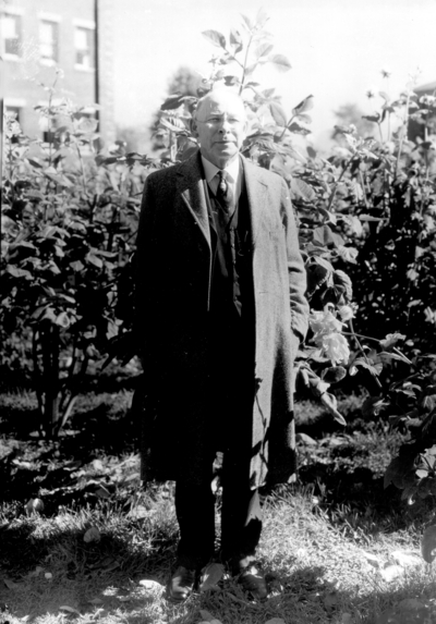Professor James Thomas Cotton Noe standing in Hart Dahlia garden by Engineering building
