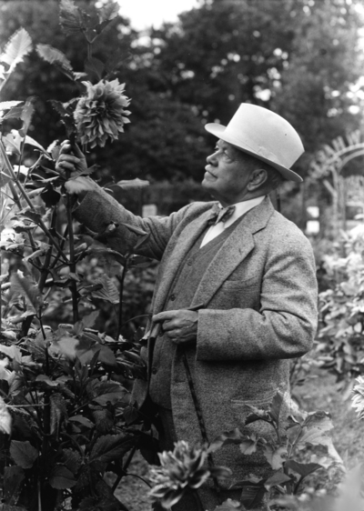 Dean F. Paul Anderson standing with the Dahlias