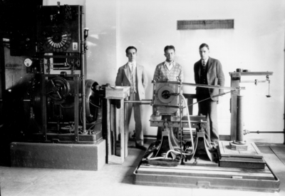 Three men with a machine