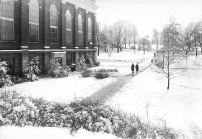 People walking past Alumni gym in winter