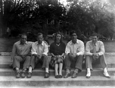 Four men, one woman seated on steps