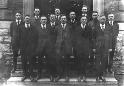 Thirteen unidentified men in group photograph in front of Mathews Building