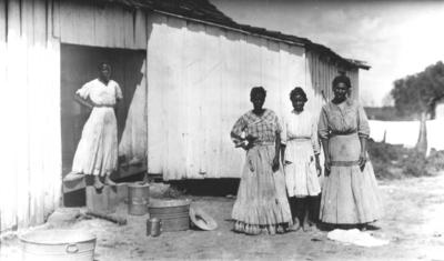 Four unidentified African-American women in front of a house or shed