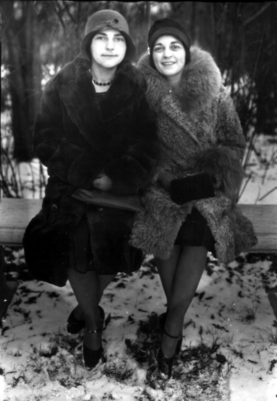 Two women in winter coats seated on a bench