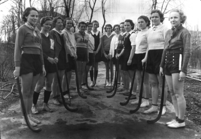 Women's field hockey team posing with sticks