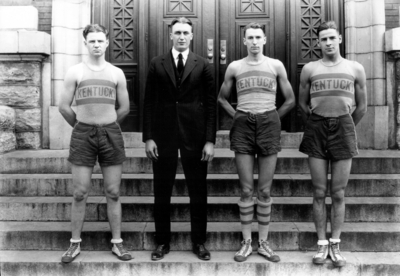 Men's basketball team members (four men, one in suit)