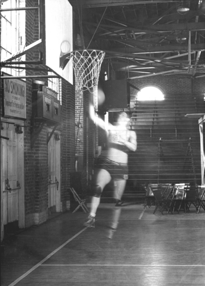 Basketball player doing a lay-up inside Alumni Gym