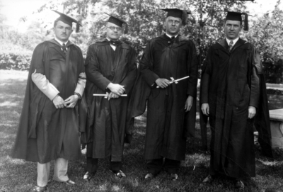 Commencement, four men in caps and gowns