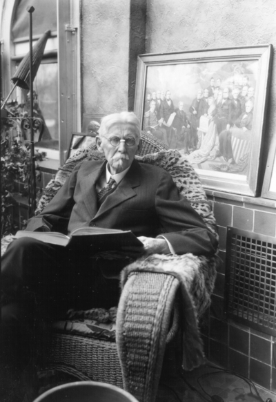 Older man in a chair reading, possibly W. D. Funkhouser