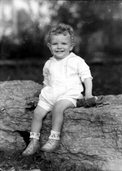 Professor C. M. Knapp and family child on a rock or low wall