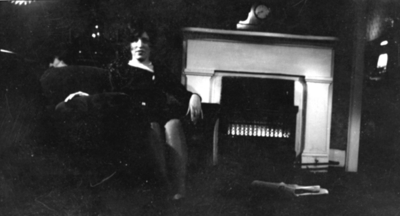 Unidentified woman by fireplace