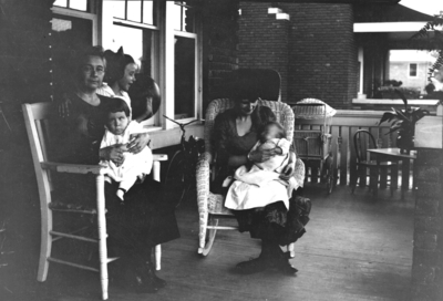 Unidentified women on porch with children
