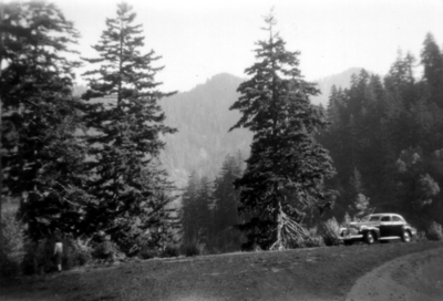Old car beside road, mountain scene