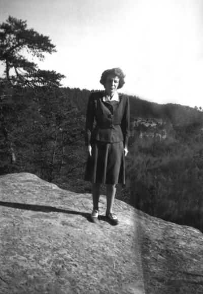Unidentified woman on mountain top rock