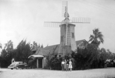 Four unidentified people in front of a windmill