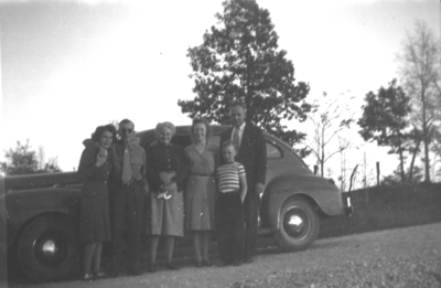 Six unidentified people in front of old car