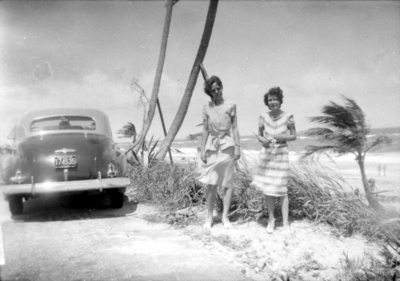 Two unidentified women standing by old car