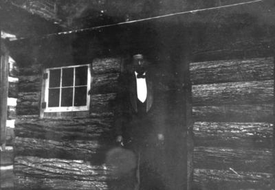 Unidentified African American man in door of log cabin