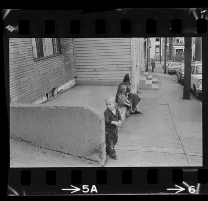 Woman and children sitting on a stoop, A back alley, A stairwell