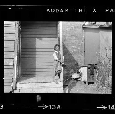 Children on bikes, Girl standing on porch, Children outside by laundry