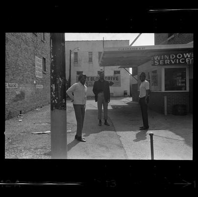 African-American man sitting, Three African-American men standing in alley, Two African-American men by wall
